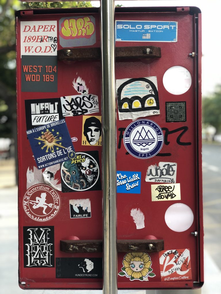 Back of a streetsign in Paris tagged with stickers